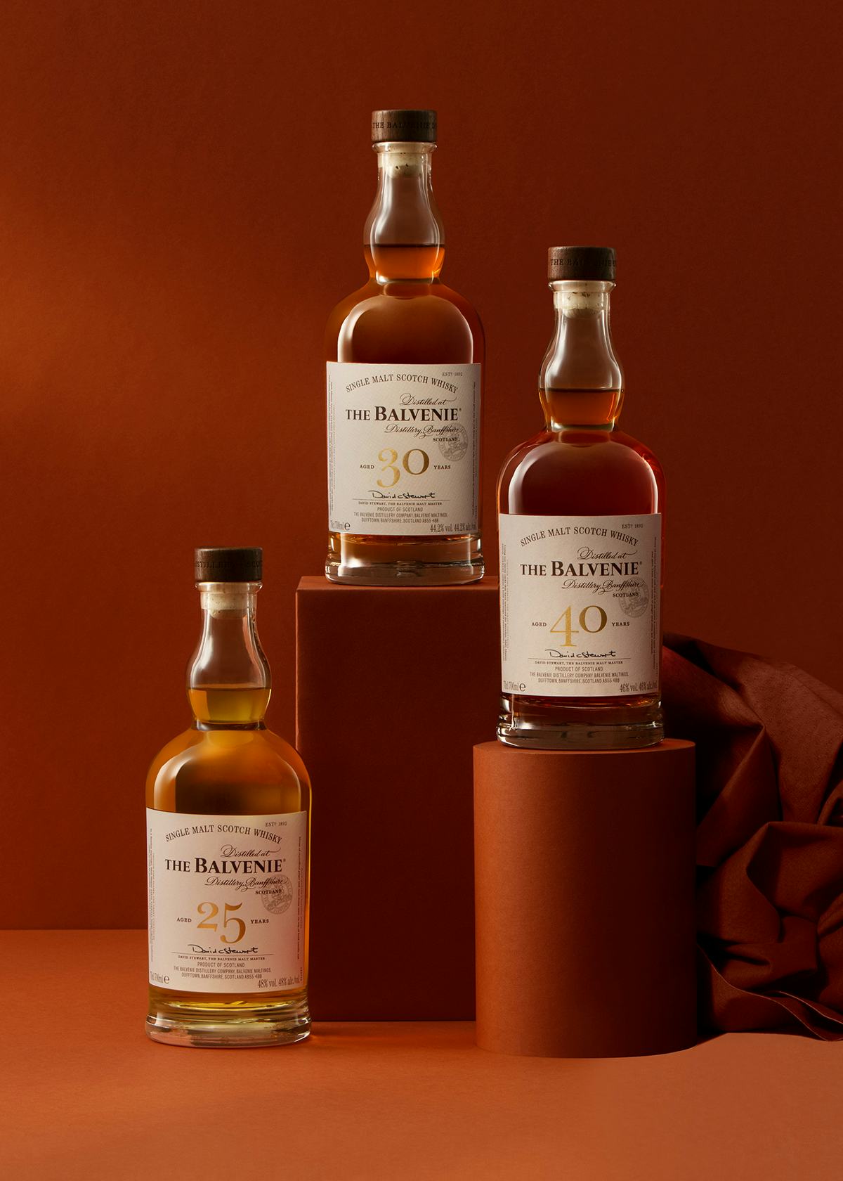 A layout image of the three Balvenie Rare Marriages whisky range bottles with a dark orange brown background.